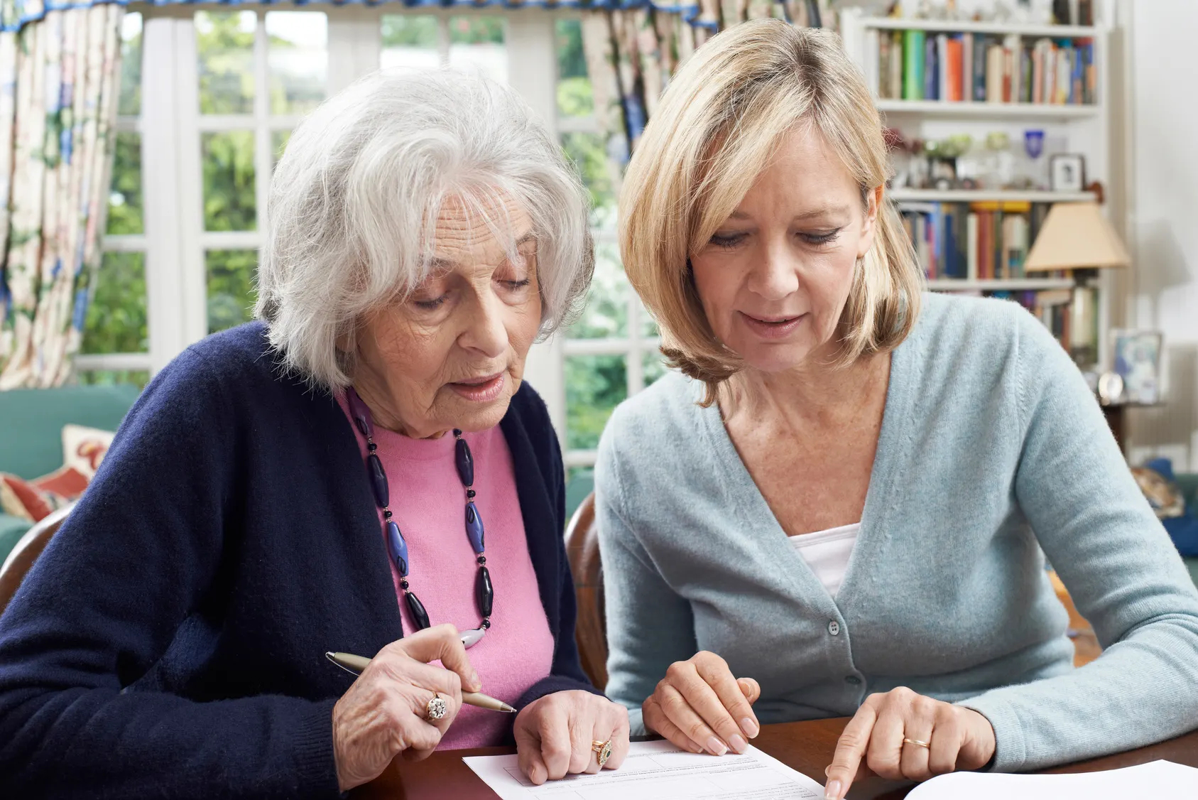 Seniorin und Tochter gehen gemeinsam Unterlagen durch